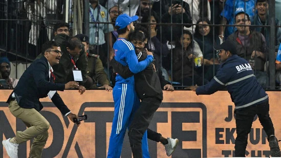 කෝලිගේ දෙපා වැද සිපගත් ඉන්දීය ප්‍රේක්ෂකයා පොලිස් කූඩුවේ! - Police detain pitch invader for hugging and touching Virat Kohli's feet during IND vs AFG 2nd T20I.