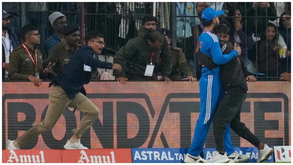 කෝලිගේ දෙපා වැද සිපගත් ඉන්දීය ප්‍රේක්ෂකයා පොලිස් කූඩුවේ! - Police detain pitch invader for hugging and touching Virat Kohli's feet during IND vs AFG 2nd T20I.